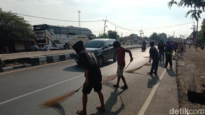Aktivitas penyapu koin di Jembatan Sewo, Sukra, Indramayu