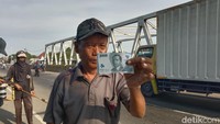 Penyapu koin tunjukkan pecahan uang kertas baru yang baru dari pengguna jalan yang melintas.