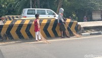 Momen penyapu koin berebut uang yang dilemparkan pengguna jalan. Bahkan mereka sering mengabaikan risiko.