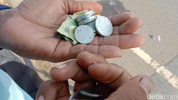 Aktivitas penyapu koin di Jembatan Sewo, Sukra, Indramayu
