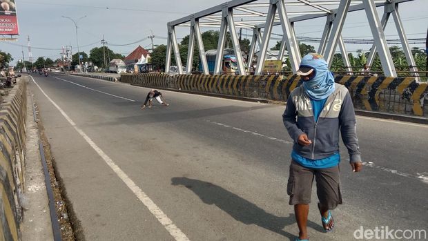 Aktivitas penyapu koin di Jembatan Sewo, Sukra, Indramayu