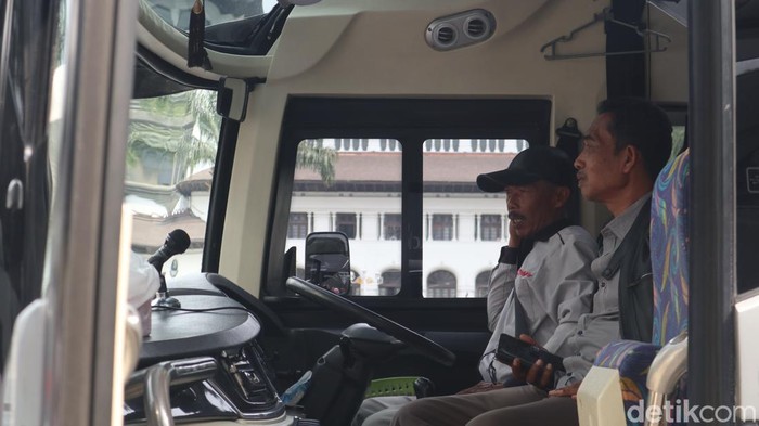 Asep Dedi (kanan) sopir bus saat akan mengantar rombongan mudik gratis dari Bandung ke Surabaya.