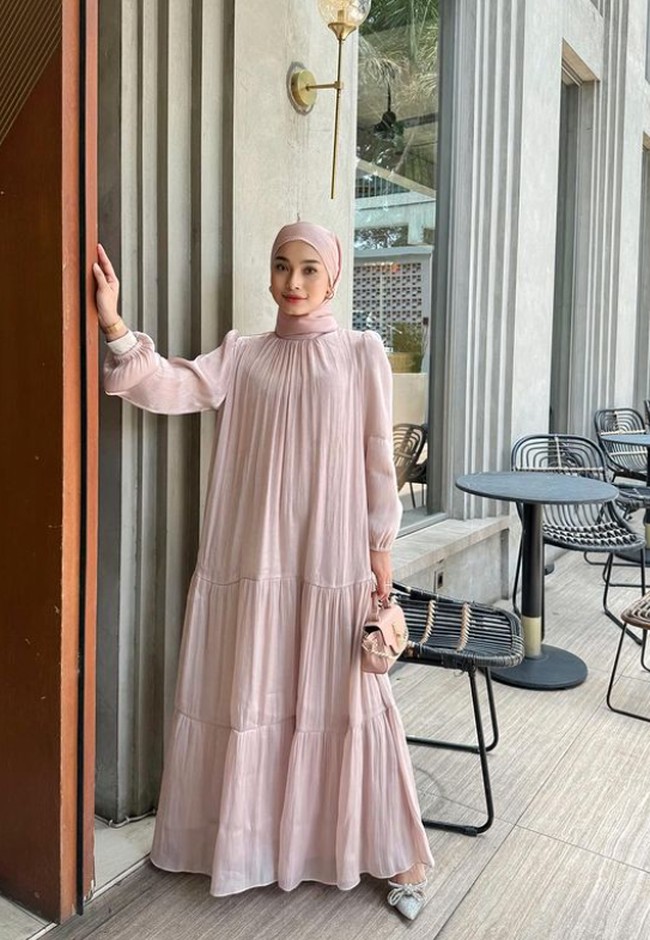 Selebgram hijab, Elina Yuwono memakai dress shimmer loose warna blush yang membuat penampilannya lebih feminin dan cantik. Dia membentuk hijab pashmina shimmer dengan diikat rapi ke belakang. Foto: Dok. Instagram @elinayuwono.