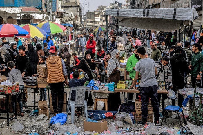 People shop from vendors in an open-air market amidst destruction in Gaza City on March 27, 2024 amid the ongoing conflict in the Gaza Strip between Israel and the Palestinian militant group Hamas. (Photo by AFP)