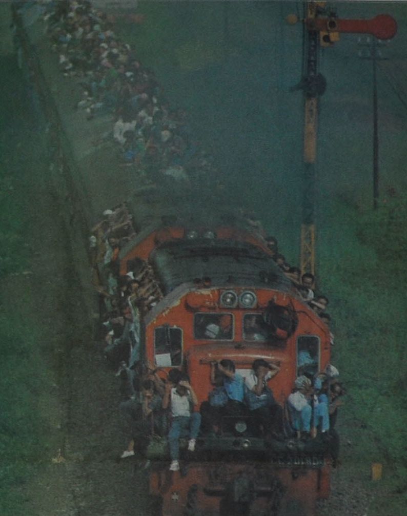 Foto: Amri Zainun/Jawa Pos. Setelah 12 jam berhimpit-himpitan di gerbong, bergelantungan di badan lok kereta api, atau duduk tanpa berpegangan sama sekali di atapnya, penumpang KA jurusan Purwokerto-Jakarta yang berangkat pukul 06.00 pagi baru mendcapai Jembatan Gedebage, Bandung, Senin sore kemarin. Masih sekitar lima jam lagi sebelum mereka sampai ke tujuan. (Harian Umum Pikiran Rakyat edisi Selasa 30 Maret1993)