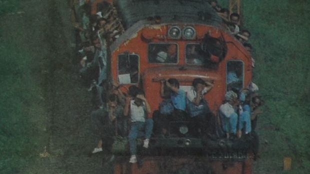 Foto: Amri Zainun/Jawa Pos. Setelah 12 jam berhimpit-himpitan di gerbong, bergelantungan di badan lok kereta api, atau duduk tanpa berpegangan sama sekali di atapnya, penumpang KA jurusan Purwokerto-Jakarta yang berangkat pukul 06.00 pagi baru mendcapai Jembatan Gedebage, Bandung, Senin sore kemarin. Masih sekitar lima jam lagi sebelum mereka sampai ke tujuan. (Harian Umum Pikiran Rakyat edisi Selasa 30 Maret1993)
