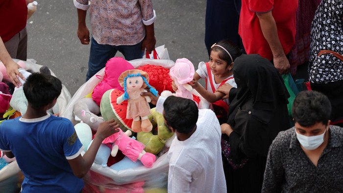A young girl looks at a doll before purchasing it during the holy month of Ramadan ahead of Eid al-Fitr celebration in Dhaka, Bangladesh, April 5, 2024. REUTERS/Mohammad Ponir Hossain