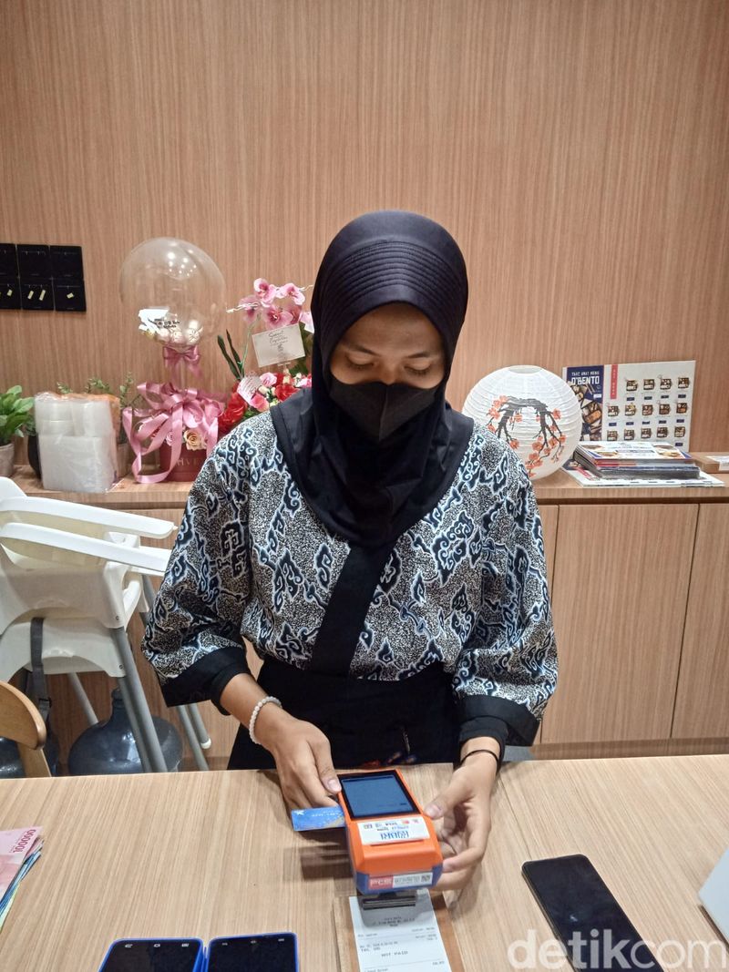 Salah satu pengunjung membayar tagihan di D'Ozara Bento dengan metode non tunai dari kartu debit BRI. (Andika Syahputra/detikcom)