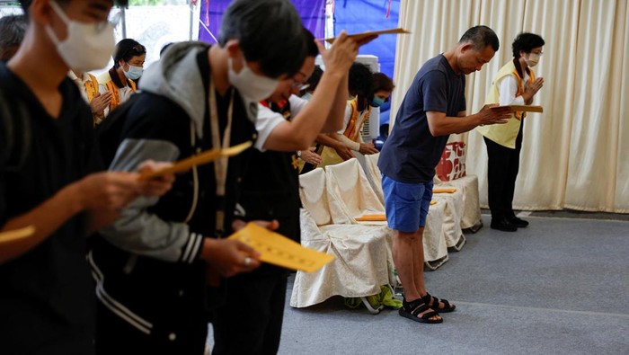 Warga Taiwan Gelar Upacara Peringatan untuk Korban Gempa People attend a religious ceremony honouring people who died during the earthquake, at a funeral parlour, in Hualien, Taiwan April 5, 2024. REUTERS/Carlos Garcia Rawlins