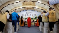 Para biksu Buddha berada di rumah duka setempat sambil melantunkan nyanyian di depan foto almarhum yang diletakkan di atas altar.  