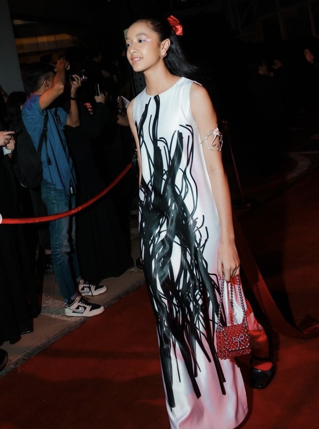 Terusan putih Aesthetic Pleasure yang dihiasi corak abstrak hitam menemani penampilan Widuri Puteri. Anak Widi Mulia dan Dwi Sasono ini melengkapi gayanya dengan tas beading merah yang unik. (Foto: Instagram)