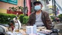 Sebagian dari mereka menggelar uang baru itu menggunakan tampah.