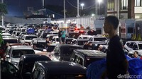 Pemudik memilih keluar dari mobilnya saat menunggu giliran masuk kapal feri. 