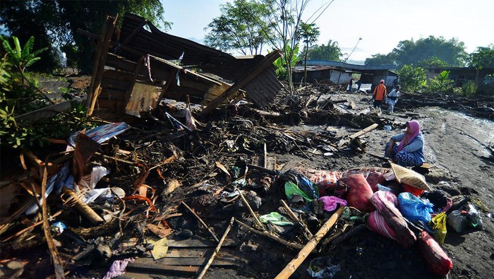 Warga berada di dekat puing-puing rumahnya yang dihanyutkan banjir lahar dingin di Nagari Bukik Batabuah, Agam, Sumatera Barat, Sabtu (6/4/2024). Data Nagari Bukik Batabuah menyebutkan banjir lahar dingin yang terjadi pada Jumat (5/4) itu menerjang 17 unit mobil dan sejumlah motor dan 40 rumah, tiga di antaranya rusak berat, serta areal pesawahan dan memutus sementara jalan alternatif mudik Pekanbaru - Padang.
