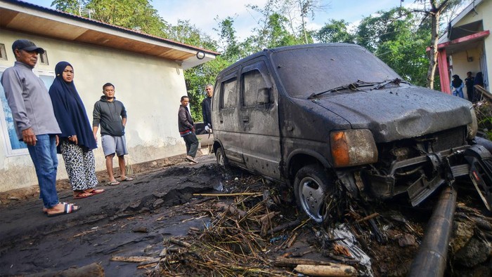 Warga membersihkan mobilnya yang terseret banjir lahar dingin di Nagari Bukik Batabuah, Agam, Sumatera Barat, Sabtu (6/4/2024). Data Nagari Bukik Batabuah menyebutkan  banjir lahar dingin  yang terjadi pada Jumat (5/4) itu menerjang 17 unit mobil dan sejumlah motor dan 40 rumah, tiga di antaranya rusak berat, serta areal pesawahan dan memutus sementara jalan alternatif mudik Pekanbaru - Padang.   ANTARA FOTO/Iggoy el Fitra/nz
