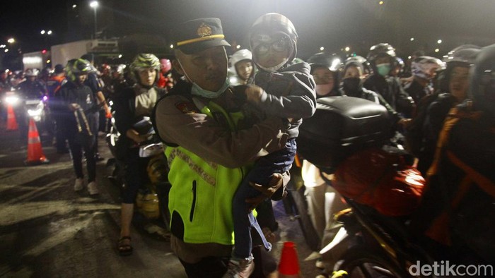 Momen Petugas Bantu Pemudik Balita Masuk Kapal Butuh perjuangan bagi para pemudik untuk bisa menyeberangan Pelabuhan Ciwandan, Cilegon, Banten. Petugas pun siap membantu.