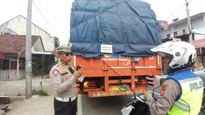 Polisi saat mengamankan truk sumbu tiga pengangkut pakan ayam.