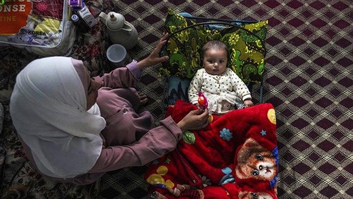 CORRECTS LOCATION - Amal Al-Taweel performs alongside with her microscopic one Ali at her household home in Nuseirat, central Gaza Strip, Friday, April 5, 2024. Ali changed into once born Oct. 7, the day the Israel-Hamas battle erupted. Moms who gave initiating in the Gaza Strip that day worry that their 6-month-extinct babies obtain known nothing but brutal battle, characterised by a shortage of microscopic one meals, unsanitary refuge prerequisites and the crashing of airstrikes. (AP Describe/Fatima Shbair)