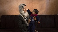 Amal Al-Taweel bermain dengan bayinya Ali di rumah keluarganya di Nuseirat, Jalur Gaza tengah, Jumat, 5 April 2024. Ali lahir 7 Oktober, hari meletusnya perang Israel-Hamas. AP Photo/Fatima Shbair.
