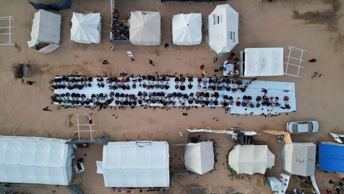 A drone view shows Palestinians, who were displaced by Israel's military offensive, gathering to have their Iftar (breaking of the fast) during the holy month of Ramadan, in Rafah in the southern Gaza Strip April 6, 2024. REUTERS/Shadi Tabatibi