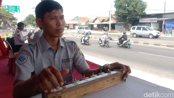 Handang Haryanto sang penghitung kendaraan mudik saat bertugas di Pos Perhitungan Kendaraan Mudik Lebaran di Kabupaten Indramayu