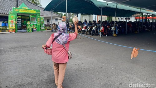 Pedagang asongan yang ada di wilayah Pelabuhan Gilimanuk, Bali saat melayani pemudik yang tengah antri masuk ke kapal, Sabtu (6/4/2024). (I Putu Adi Budiastrawan/detikBali).