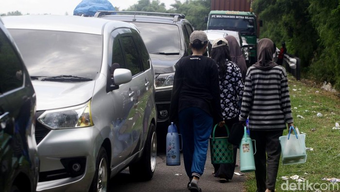 Kemacetan parah di Tol Merak dimanfaatkan oleh warga sekitar. Mereka berdagang makanan dan minuman.