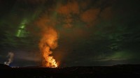 Keindahan letusan gunung yang berpadu dengan cahaya di langit.