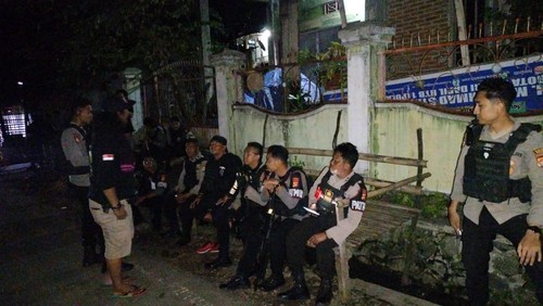 Polisi disiagakan di rumah terduga pelaku pembacokan Kadus, Sudirman hingga tewas untuk antisipasi hal-hal yang tidak diinginkan terjadi, Sabtu (6/4/2024) malam. (Dok. Polres Bima Kota)