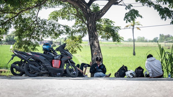Pemudik bersepeda motor di jalur pantura Pemudik bersepeda motor beristirahat di bahu jalan raya pantura, Indramayu, Jawa Barat, Minggu (7/4/2024). Pada H-3 Lebaran, pemudik bersepeda motor dari arah Jakarta menuju Jawa Tengah yang melintas di Jalur Pantura terpantau ramai.. ANTARA FOTO/Bayu Pratama S/tom.