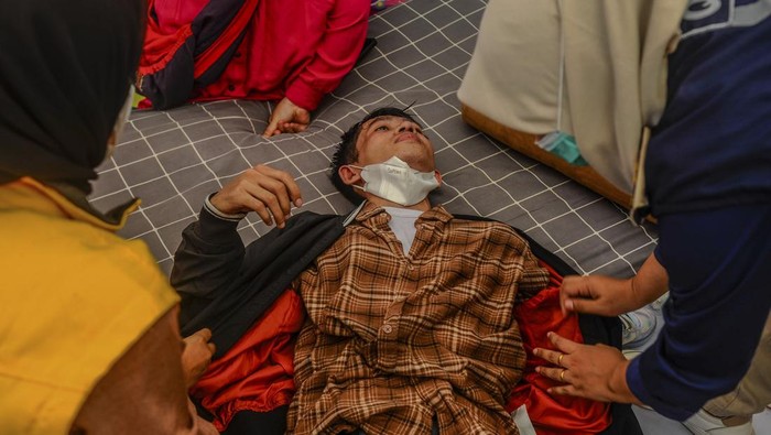 Pemudik di Pelabuhan Ciwandan kelelahan Petugas menggotong pemudik yang kelelahan menuju posko kesehatan di Pelabuhan Ciwandan, Cilegon, Banten, Minggu (7/4/2024). Sejumlah pemudik yang hendak masuk pelabuhan tersebut mengalami kelelahan dan ada yang pingsan akibat menunggu waktu antrean yang lama dan disertai cuaca panas. ANTARA FOTO/Muhammad Bagus Khoirunas/nym.