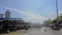 Petugas Pemadam Kebakaran menyemprotkan air ke jalanan di Pelabuhan Ciwandan, Kota Cilegon, Banten, Minggu (7/4/2024).