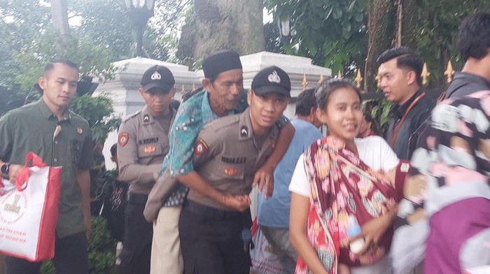 Seorang lansia digendong polisi agar bisa antre sembako dari Jokowi