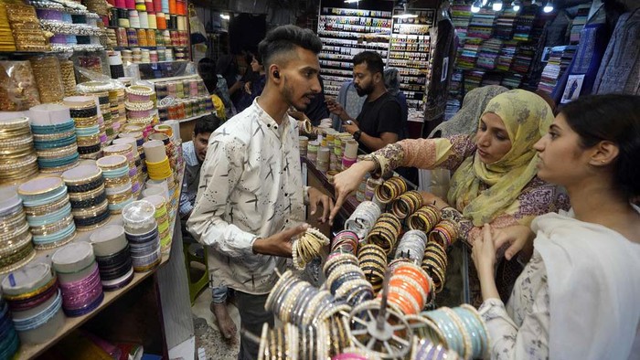 A girl browse traditional artificial jewelry while she visit a market to shop for the upcoming Eid al-Fitr celebrations, in Karachi, Pakistan, Sunday, April 7, 2024. Eid al-Fitr marks the end of the Islamic holy month of Ramadan. (AP Photo/Fareed Khan)