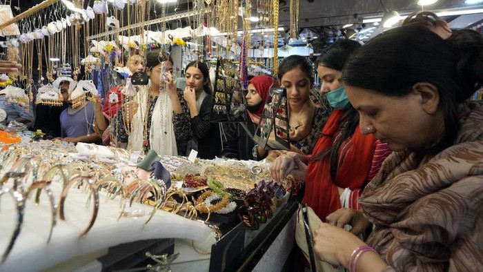 A girl browse traditional artificial jewelry while she visit a market to shop for the upcoming Eid al-Fitr celebrations, in Karachi, Pakistan, Sunday, April 7, 2024. Eid al-Fitr marks the end of the Islamic holy month of Ramadan. (AP Photo/Fareed Khan)