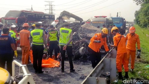 Petugas saat mengevakuasi korban bus tabrak Gran Max di Tol Japek