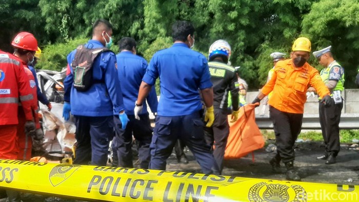 Polisi saat mengevakuasi jasad korban kecelakaan beruntun di Km 58 Tol Cikampek, Senin (8/4/2024).