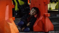 Seorang anak bersandar di pembatas jalan.