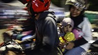 Seorang anak naik motor bersama kedua orangtuanya masuk ke kapal penyeberangan.