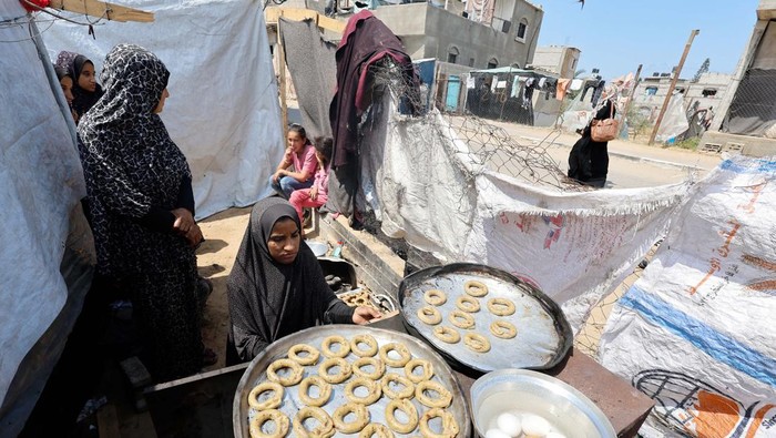 A displaced Palestinian family makes traditional cakes as they prepare for the Eid al-Fitr holiday which marks the end of the Muslim holy fasting month of Ramadan, amid the ongoing conflict between Israel and Hamas, at a tent camp in Rafah, in the southern Gaza Strip, April 8, 2024. REUTERS/Mohammed Salem