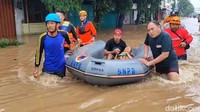 Petugas BPBD Kota Pasuruan mengevakuasi warga yang terdampak banjir.