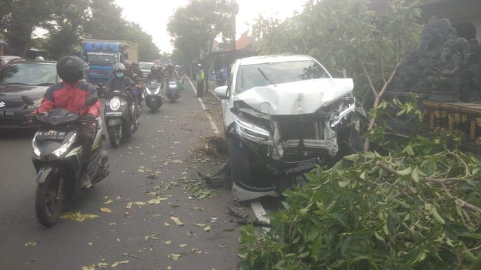 Mobil ringsek usai menabrak pohon dan tukang sapu di pinggir jalan Raya Denpasar-Gilimanuk, Selasa (9/4/2024). (Dok Polres Badung)