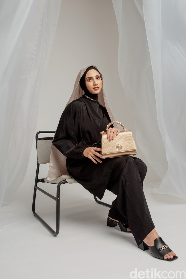 Elegan dalam siluet trapesium yang klasik, top handle bag berbahan kulit ini hadir dalam pilihan warna emas untuk edisi khusus holiday teranyar. (Foto: Ila Scaffer/Aigner Indonesia; wardrobe: Trans Fashion Indonesia; perhiasan: The Palace)