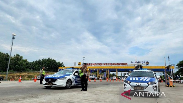 Petugas siap mengawal mobil yang akan melintas ke arah barat atau Jakarta setelah penutupan jalur satu arah di gerbang Tol Kalikangkung Semarang, Selasa (9/4/2024).