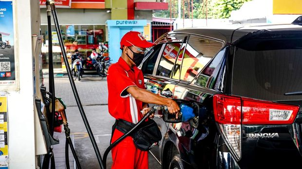 Petugas SPBU sedang mengisi BBM di salah satu mobil pelanggan.