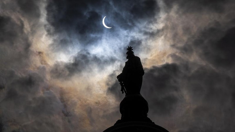 The Statue of Freedom on top of the U.S. Capitol stands as the moon partially covers the sun during a total solar eclipse, as seen from Capitol Hill, Monday, April 8, 2024, in Washington. (AP Photo/Alex Brandon)