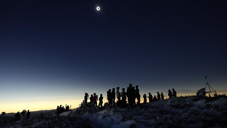 Skiers and hikers take in the view from the Appalachian Trail at the summit of Saddleback Mountain during the total solar eclipse, Monday, April 8, 2024, near Rangeley, Maine. (AP Photo/Robert F. Bukaty)