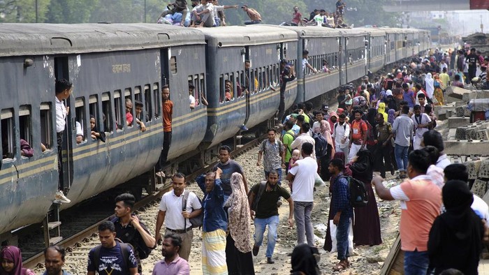 Suasana Mudik Idul Fitri Penuh Sesak di Bangladesh Bangladeshi Muslims maneuver their way on the roof of an overcrowded train to travel home for Eid al-Fitr celebrations, at a railway station in Dhaka, Bangladesh, Tuesday, April 9, 2024. Hundreds of thousands of people working in Dhaka are leaving for their hometowns to celebrate the upcoming Eid al-Fitr with their families. (AP Photo/Mahmud Hossain Opu)