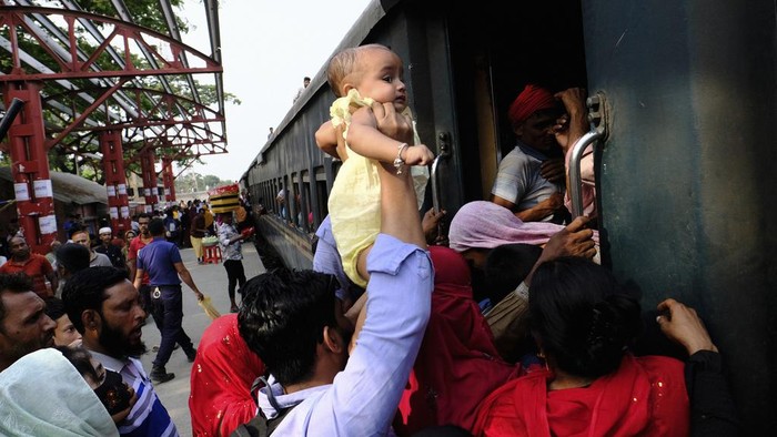 Suasana Mudik Idul Fitri Penuh Sesak di Bangladesh Bangladeshi Muslims maneuver their way on the roof of an overcrowded train to travel home for Eid al-Fitr celebrations, at a railway station in Dhaka, Bangladesh, Tuesday, April 9, 2024. Hundreds of thousands of people working in Dhaka are leaving for their hometowns to celebrate the upcoming Eid al-Fitr with their families. (AP Photo/Mahmud Hossain Opu)