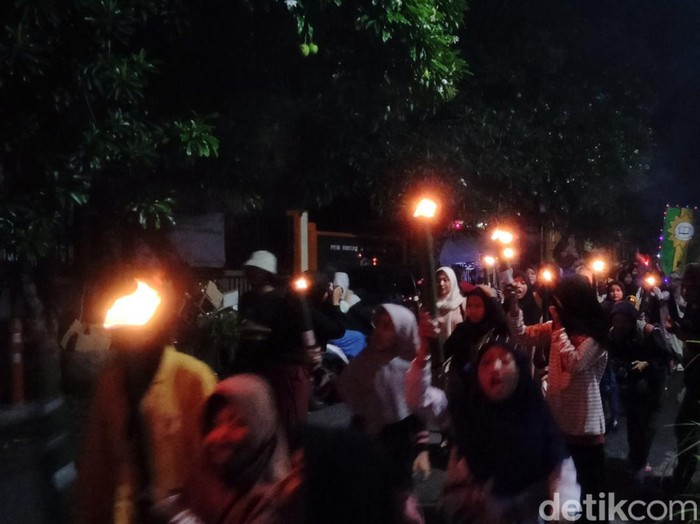 Takbiran keliling sembari membawa obor yang dilakukan pelajar Pemuda Muhammadiyah di Kenjeran, Surabaya.
